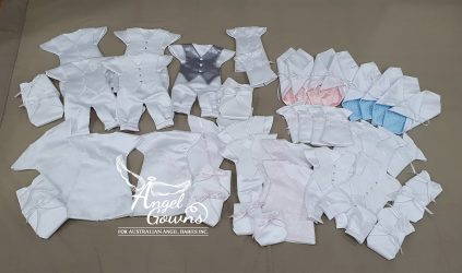 A display of all the gowns, rompers, wraps and nappies made from a single wedding dress. This transformation will help provide packs to more than 20 families.
