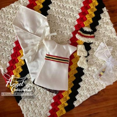 A package displaying a gown, wrap, blanket, beanie, booties, nappy and a keepsake charm. This package uses the colours of the Australian Aboriginal Flag.